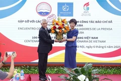 A representative of Prensa Latina News Agency in Vietnam presents flowers to General Director of the Vietnam News Agency Vu Viet Trang to congratulate the agency on the occasion of the 100th anniversary of Vietnamese Revolutionary Press Day. (Photo: VNA)