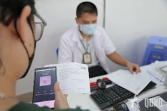 A patient pays hospital fees using cashless transactions (Photo: qdnd.vn)