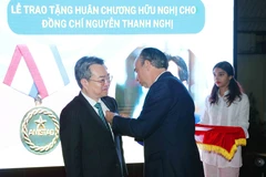 Cuban Ambassador to Vietnam Rogelio Polanco Fuentes bestows the Medal of Friendship on Nguyen Thanh Nghi, member of the Party Central Committee and head of its Commission for Policies and Strategies, on December 26. (Photo: VNA)