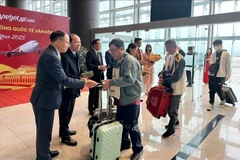 Representatives from Quang Ninh's Van Don district and Tourism Department welcome and give lucky money to visitors at Van Don airport. (Photo: VNA)