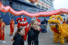 Tourists from Celebrity Solstice, the first cruise ship to arrive in Quang Ninh in 2026, enjoy taking photos with a Vietnamese lion and dragon dance troupe. (Photo: VNA)