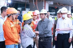 Prime Minister Pham Minh Chinh (second from the right) extends New Year greetings to workers at the construction site of the Terminal 3 project at Tan Son Nhat International Airport in Ho Chi Minh City. (Photo: VNA)