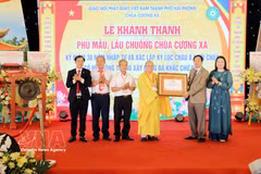 The certificate recognising Cuong Xa Pagoda as the temple with the largest system of stone walls engraved with the Buddhist swastika symbol is handed over to the pagoda's representatives at a ceremony held on May 3. (Photo: VNA)