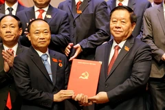 Chairman of the Party Central Committee's Commission for Information, Education, and Mass Mobilisation Nguyen Trong Nghia (R) presents the Politburo's decision to Thai Dai Ngoc, who now serves as Secretary of the Gia Lai provincial Party Committee. (Photo: VNA)