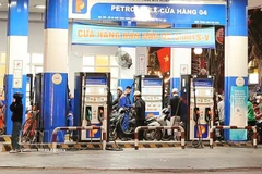 Motorcycle riders refill their vehicles at a petrol station in Hanoi (Photo: VNA)