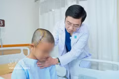 Dr Truong Thanh Tinh, head of the Department of Neurosurgery under the University Medical Centre Ho Chi Minh City, gives a post-surgery check-up on the 12-year-old patient. (Photo: VNA)