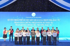 Prime Minister Pham Minh Chinh (centre, first row), and leaders of Binh Duong province handover investment certificates to enterprises. (Photo: daibieunhandan.vn)