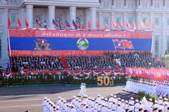 A military parade and march held to celebrate the 50th National Day of the Lao People’s Democratic Republic. (Photo: VNA)