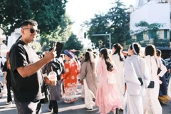 A foreigner records moments at the Vietnam Costumes Festival in Hanoi on November 15, 2025. (Photo: sggp.org.vn) 