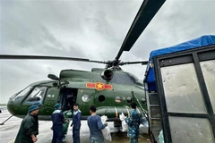 Relief supplies are loaded onto a helicopter for delivery to residents who remain isolated by floodwaters in the south-central provinces. (Photo: VNA)