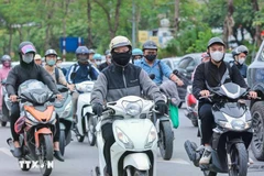 Motorcyclists wear warm clothes and gloves when traveling outdoors (Photo: VNA)