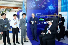 Delegates visit the United Nations technology exhibition space at the Hanoi Convention Opening Ceremony. (Photo: VNA)