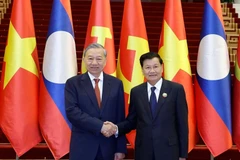 Party General Secretary To Lam (L) meets with LPRP General Secretary and President of Laos Thongloun Sisoulith during the visit. (Photo: VNA)