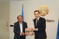 Minister of Culture, Sports and Tourism Nguyen Van Hung (left) presents a gift to Beka Jakeli, Chief of External Relations at UN Tourism. (Photo: The Ministry of Culture, Sports and Tourism)