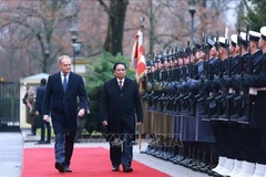 Prime Minister Pham Minh Chinh (R) and Polish Prime Minister Donald Tusk inspect the guard of honour at the welcome ceremony. (Photo: VNA)