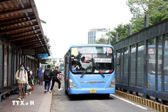 Passengers get on a bus on Ham Nghi street in Ho Chi Minh City. (Photo: VNA)