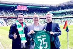 Vietnamese Ambassador to Germany Vu Quang Minh (C) presented with a jersey from Werder Bremen club (Photo: VNA)