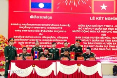 Representatives from Laos and Vietnam sign the agreement at the ceremony. (Photo published by VNA)