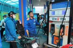 Customers buy and sell fuel at a Petrolimex petrol station. (Photo: VNA)