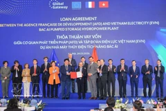 Deputy Prime Minister Ho Duc Phoc and European Commissioner for International Partnerships Jozef Sikela witness the signing ceremony of a loan agreement between the French Development Agency (AFD) and Vietnam Electricity in Hanoi on March 24. (Photo: VNA) 