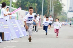 Boys and girls join the Hanoi run in response to Earth Hour 2026. (Photo: VNA)