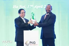 Prime Minister Pham Minh Chinh (left) hands over the logo of hosting the fifth Partnership for Green Growth and the Global Goals (P4G) Summit to Ethiopian Prime Minister Abiy Ahmed Ali. (Photo: VNA)