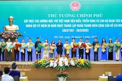Prime Minister Pham Minh Chinh presents flowers to outstanding young people. (Photo: VNA)