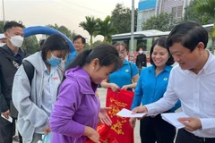 Vo Van Minh, Chairman of the Binh Duong provincial People's Committee hands over gifts to workers returning home for Tet. (Photo: VNA)