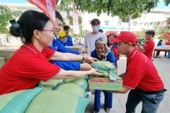 Staff members of the Ninh Thuan provincial Red Cross Society assist elderly people with difficult circumstances in transporting goods at a humanitarian market fair. (Photo: VNA)