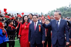 Students welcome Party General Secretary To Lam and Prime Minister Pham Minh Chinh to the ceremony (Photo: VNA)