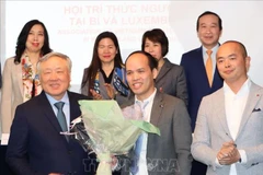 Permanent Deputy Prime Minister Nguyen Hoa Binh (first, left, front) presents flowers to ViLaB leader (Photo: VNA)