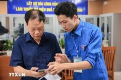 Guiding a local how to apply for administrative procedures on a mobile phone (Photo: VNA)