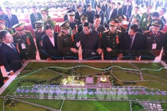 Prime Minister Pham Minh Chinh (front, fourth from right) and officials view a model of the Gia Binh Airport project (Photo: VNA)