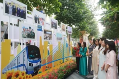 Visitors look at photos at an exhibition which highlights glorious milestones of the Communist Party of Vietnam (Photo: VNA)