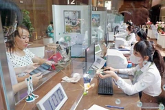 Customers completing a transaction at a Vietcombank branch. (Photo: VNA)