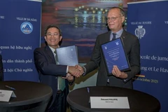 Vice Chairman of the Da Nang People’s Committee Tran Nam Hung (left) and Mayor of Le Havre Édouard Philippe exchange a MoU establishing cooperation and friendship relations between the two port cities. (Photo: VNA)