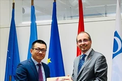 Vietnamese Ambassador to Austria Vu Le Thai Hoang (L) presents a gift to Dr. Arnold Kammel, Secretary General of the Austrian Ministry of Defence. (Photo: VNA)