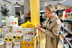 A French customer is tasting Vietnamese lychee. (Photo: VNA)