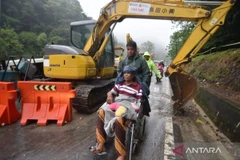 Villagers walk along a flood-hit road under repair in Tanah Datar, West Sumatra, December 10, 2025. (Photo: Antara)