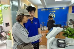 Citizens use an AI robot to assist with administrative procedures at Cua Nam ward in Hanoi. (Photo: VNA)