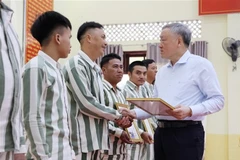 Permanent Deputy Prime Minister Nguyen Hoa Binh presents amnesty certificates to qualified prisoners formerly held at A2 Prison. (Photo: VNA)