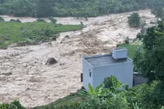 Floodwaters surge past a house in the northern province of Lai Chau, moments before it collapsed completely. (Photo: VNS/VNA)