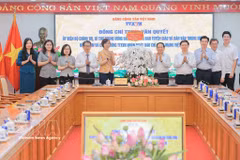 Head of the Party Central Committee’s Commission for Information, Education and Mass Mobilisation Trinh Van Quyet presents congratulatory flowers to VNA (Photo: VNA)
