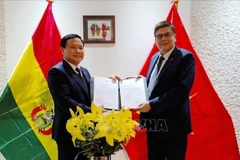 Ambassador Bui Van Nghi (L) presents the decision of Deputy Prime Minister and Minister of Foreign Affairs Bui Thanh Son on reappointing Miguel Angel Pérez Peña as Honorary Consul of Vietnam in Bolivia. (Photo: VNA)