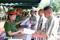 Police officers of the Phu Son 4 Prison present amnesty decisions to persons granted amnesty in 2025. (Photo: VNA)