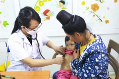 A doctor provides health check-up for a girl at Dien Bien Provincial General Hospital. (Photo: VNA)