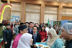 Vietnamese Ambassador to Brunei Tran Anh Vu introduces 'pho' and 'nem ran' to a Brunei official (Photo: VNA)