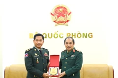 Deputy Chief of the General Staff of the Vietnam People’s Army Sen. Lieut. Gen Phung Sy Tan presents a souvenir to Gen. Phorn Nara, Secretary General of the National Authority for the Prohibition of Chemical, Nuclear, Biological and Radiological Weapons of Cambodia (CBRNE) in Hanoi on December 23 (Photo: qdnd.vn)