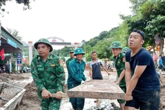 Border guard soldiers from Nam Can border post help residents in Muong Xen commune, Nghe An province, clean up and recover after the floods. (Photo: VNA)