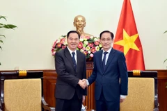 Minister of Foreign Affairs Le Hoai Trung (R) and Lao Minister of Education and Sports Thongsalith Mangnomek at their meeting in Hanoi on December 16. (Photo: Vietnamese Ministry of Foreign Affairs)